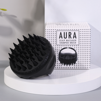 Hipoalergiczny masażer AURA do mycia i masażu głowy, czarny silikon. Widok z przodu na białym podium z pudełkiem.