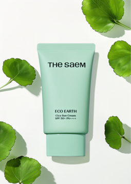 The Saem Eco Earth Clear Sun Cream SPF 50+ w miętowej tubce, na białym tle z zielonymi liśćmi, widok z przodu.