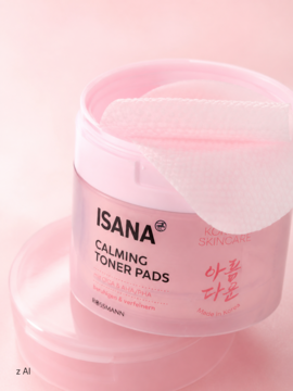 Różowe, otwarte opakowanie Isana Korean Skincare Calming Toner Pads z białymi płatkami tonizującymi.