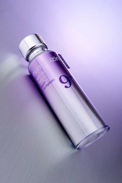 numeeuzin 9 liftingująca esencja z koenzymem NAD. Srebrna butelka na lśniącym tle, widok pod kątem.