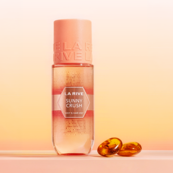LA RIVE Sunny Crush: Perfumy w podłużnej butelce z różową nakrętką na pomarańczowym tle, obok bursztynowe kapsułki.
