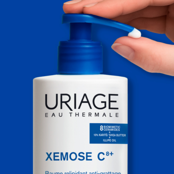 Uriage Xemose C8+ kojący olejek w kremie dla skóry atopowej. Biała butelka, niebieska pompka, dłoń wyciska kroplę.