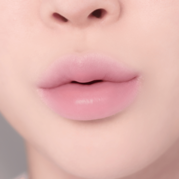 Zbliżenie na pełne, naturalnie różowe usta z delikatnym, nawilżającym wykończeniem. Widok z przodu.