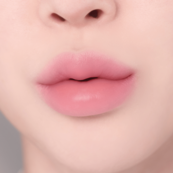 Zbliżenie na pełne, miękkie, różowe usta z rozmyciem i efektem gradientu, ukazujące naturalny wygląd.