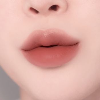 Zbliżenie na pełne usta z matowym makijażem ombre: ciemny róż w centrum, miękko rozmyty do jasnego beżu.