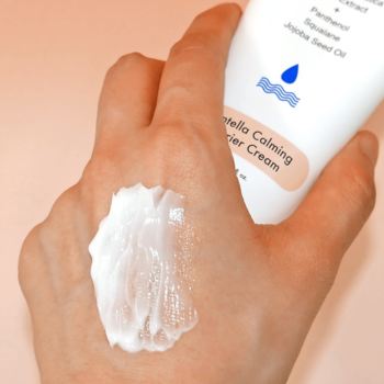 Łagodzący krem Centella Calming Barrier Cream na dłoń, biała tubka, widoczny gęsty krem o kojącej teksturze.