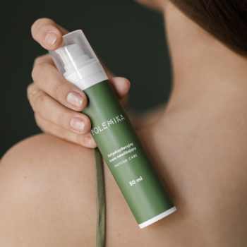 Polemika antyoksydacyjny krem nawilżający 50ml w zielonej butelce z pompką, trzymany przez dłoń przy ramieniu.