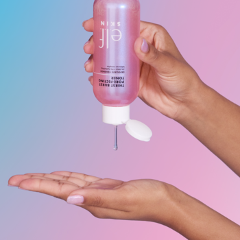 Ręka dozuje różowy płyn E.L.F. SKIN Power Grip z butelki na dłoń, na gradientowym tle niebiesko-różowym.