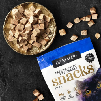 Dr Malou liofilizowane kostki z tuńczyka dla kota, w złotym naczyniu i obok niebieskiej paczki, widok z góry.