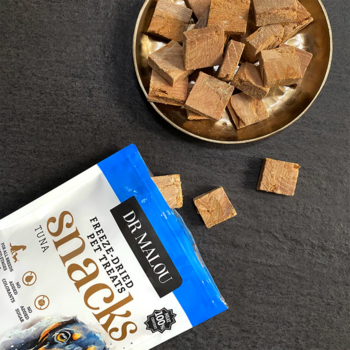 Dr Malou liofilizowane kostki z tuńczyka dla psa, w otwartym opakowaniu i złotej miseczce.