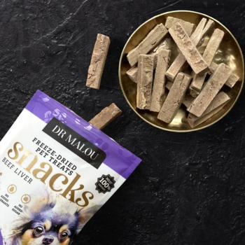 Dr Malou liofilizowana wątroba wołowa dla psa. Otwarte fioletowe opakowanie i złota miska pełna przysmaków, widok z góry.