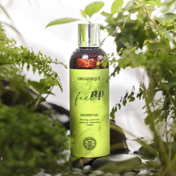 ORGANIQUE feel UP żel pod prysznic, limonkowo-zielona butelka z kroplami wody wśród świeżej zieleni.