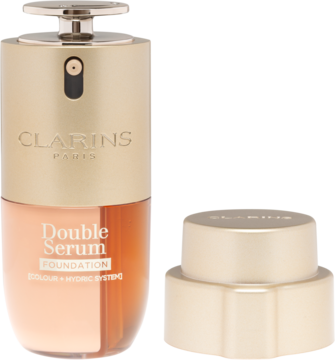 Clarins Double Serum Foundation: złota butelka z pompką i bursztynowym fluidem, obok złota nakrętka.