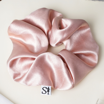 Jasnoróżowa satynowa gumka Scrunchie LILU, gładka, z metką Sister Young, na jasnym tle, widok z góry.
