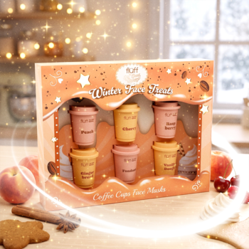 Zestaw Fluff Winter Face Treat, sześć masek Coffee Cups w pomarańczowym pudełku, na tle świątecznej kuchni.
