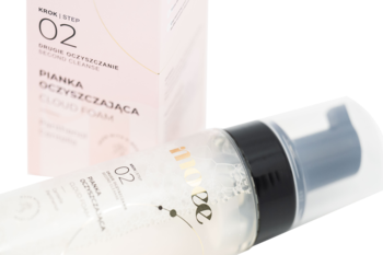 Moee Cloud Foam, delikatna pianka oczyszczająca, przezroczysta butelka z czarną pompką i logo 02, leżąca pod kątem.
