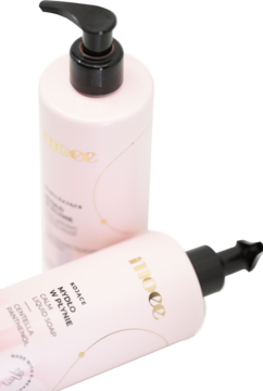 Dwie różowe butelki mydła Moee Calm Liquid Soap z wąkrotką i pantenolem, jedna leżąca, z czarnymi pompkami.