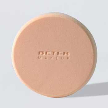 Okrągła, jasnobeżowa gąbka do makijażu Rubycell Beter Makeup z wytłoczonym logo, widok z góry.