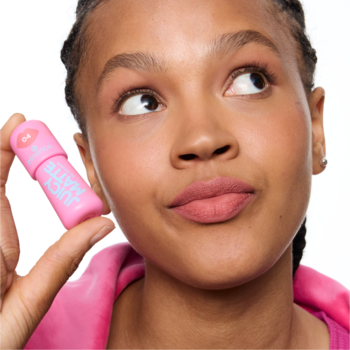 Zbliżenie na kobietę z matową pomadką essence JUICY MATTE 04 w musie na ustach i w ręku.