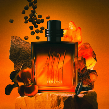 Cerruti 1881 Essence, męskie perfumy, flakon w kształcie prostopadłościanu na kamiennym cokole, pomarańczowe tło.