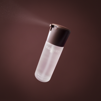 Yves Rocher, transparentny spray do twarzy unoszący się w powietrzu, z brązową nakrętką i delikatną mgiełką.