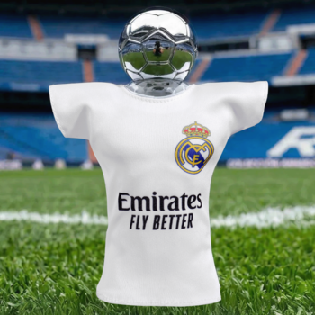 Flakon zapachu Real Madrid w kształcie białej koszulki z godłem i logo sponsora, srebrna piłka, na tle stadionu.
