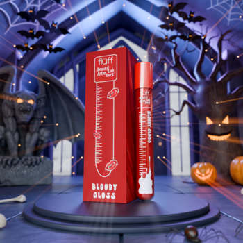Czerwony błyszczyk Fluff Bloody Gloss i pudełko, na postumencie w tle halloweenowego zamku z nietoperzami.
