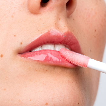 Usta aplikujące Serum Lip Wonder. Transparentne serum na ustach z XL aplikatorem doe’s foot. Usta są błyszczące i pełne.