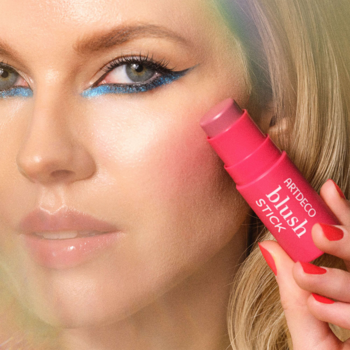 Kobieta z makijażem nakłada różowy, kremowy róż w sztyfcie Artdeco Blush Stick na policzki.