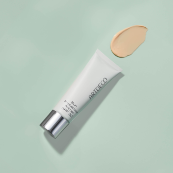 ARTDECO Sun Protection Primer SPF 30 w białej tubce z srebrną zakrętką, na zielonym tle, obok beżowy swatch.