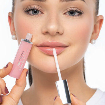 Zbliżenie na kobietę aplikującą różowy błyszczyk ARTDECO Glossy Lip Volumizer, optycznie powiększający usta.