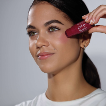 Kobieta nakłada żelowy róż w sztyfcie Artdeco Gel.ly Blush Stick Berry, widoczny naturalny rumieniec na policzku.