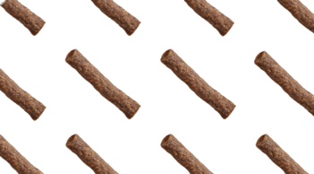 Wiele ciemnobrązowych, teksturowanych rurek John Dog Soft Bites Rolls z wołowiny, ułożonych na czarnym tle.