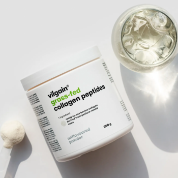 Biały słoik Vilgain Grass-Fed Collagen Peptides 300g, z zielonym napisem, obok biały proszek i szklanka z płynem. Widok z góry.