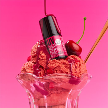 Czerwony lakier żelowy essence UV GEL NAIL 222 Cherry On Shake, w pucharku z truskawkowymi lodami i wiśniami.