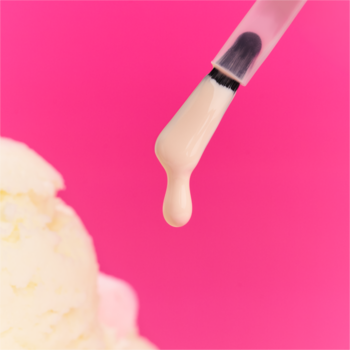 Beżowy lakier żelowy essence UV GEL NAIL 220 kapie z aplikatora na lody, różowe tło.