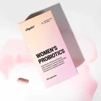 Vilgain Probiotyki dla Kobiet, różowo-pomarańczowe opakowanie z kapsułką, widok z góry, białe tło.