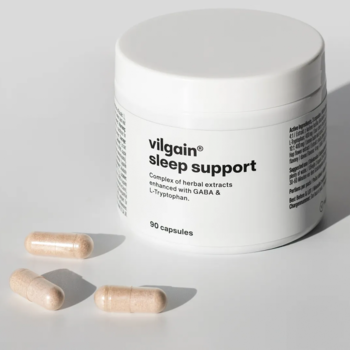 Biały słoik Vilgain Sleep Support i trzy jasnobrązowe kapsułki obok, na jasnym, jednolitym tle.