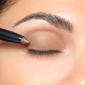 Zbliżenie: Artdeco High Performance Eyeshadow Stylo Benefit Pearl Brown aplikowany na powiekę zamkniętego oka.