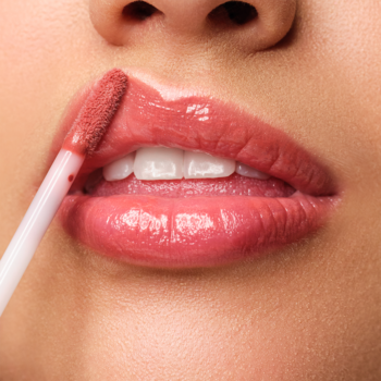 Aplikacja błyszczyka Artdeco Plumping Lip Fluid Goddess. Różowe, pełne usta z lśniącym efektem mokrego połysku.