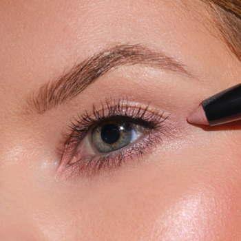 Zbliżenie na oko modelki, która aplikuje beżowy cień w sztyfcie Artdeco High Performance Eyeshadow Stylo.