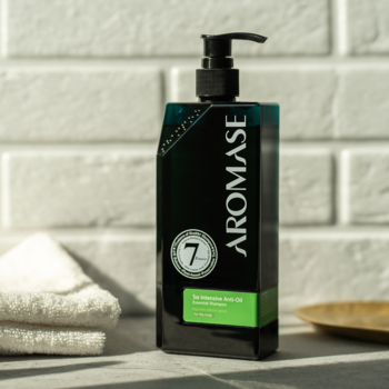 Seboregulujący szampon AROMASE do przetłuszczającej się skóry głowy w czarnej butelce z pompką, widok z przodu.