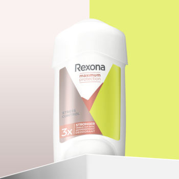 Antyperspirant Rexona Maximum Protection Stress Control w białym opakowaniu, z różowo-zieloną etykietą, na pastelowym tle.