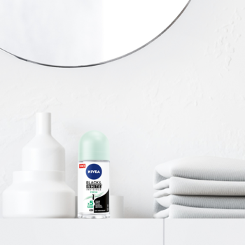 NIVEA Black & White Fresh 50 ml roll-on, butelka z zieloną nakrętką na białej półce w łazience.