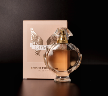 Paco Rabanne Olympea damska woda perfumowana, flakon w kształcie laurowego wieńca ze złotym korkiem, obok pudełko.
