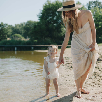 Matka i dziecko boso na plaży, symbol delikatności pieluszek Bambiboo z bambusem dla wrażliwej skóry.