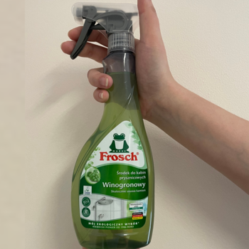 Zielony spray Frosch Winogronowy do łazienki, butelka z recyklatu, trzymany w dłoni. Skutecznie usuwa kamień i mydło.