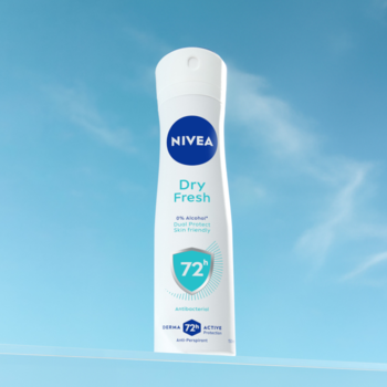 Antyperspirant NIVEA Dry Fresh 72h w białym sprayu, dla kobiet, widok z przodu, błękitne tło.