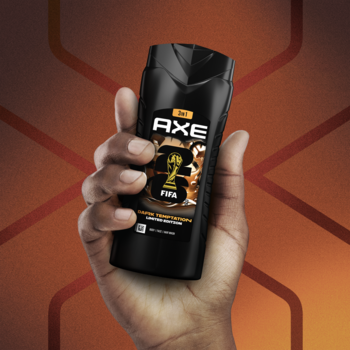 AXE męski żel pod prysznic 3w1 Dark Temptation, czarna butelka z logo FIFA, trzymana w dłoni.