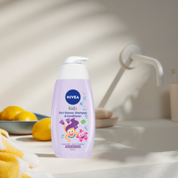 NIVEA KIDS 2w1 żel, szampon, odżywka w fioletowej butelce z pompką, rysunkowe postacie, na blacie.